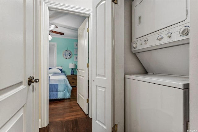 clothes washing area featuring ceiling fan, ornamental molding, stacked washer and clothes dryer, and dark hardwood / wood-style floors