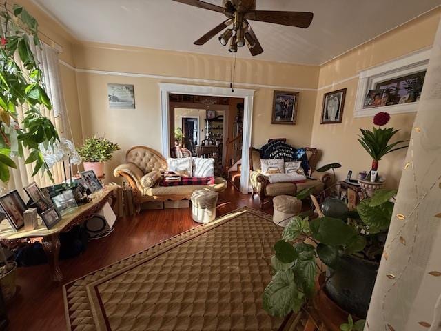 living area with wood-type flooring and ceiling fan