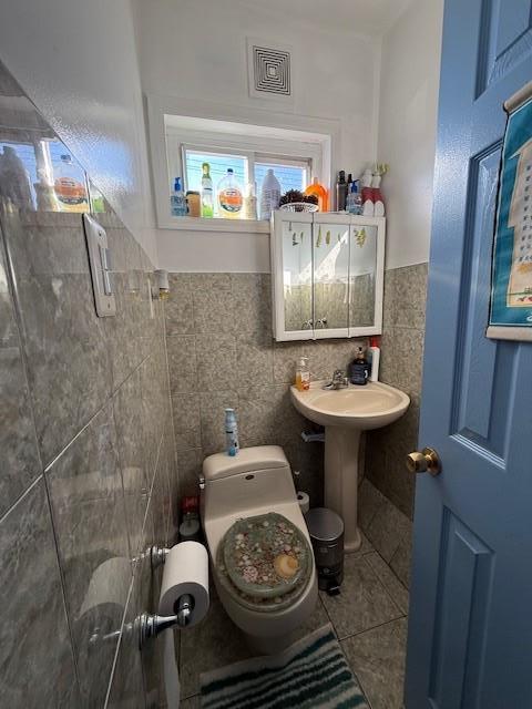 bathroom featuring tile walls, sink, tile patterned flooring, and toilet