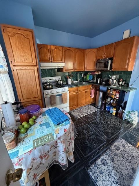 kitchen with sink, white range with gas stovetop, and backsplash