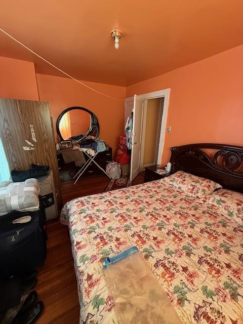 bedroom with dark hardwood / wood-style flooring