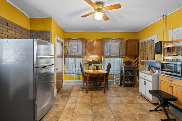 kitchen featuring light tile patterned flooring, ceiling fan, baseboard heating, stainless steel appliances, and crown molding