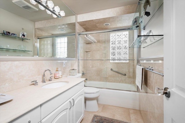 full bathroom with tasteful backsplash, tile walls, enclosed tub / shower combo, vanity, and toilet