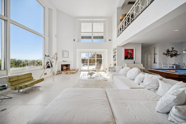 living room with a towering ceiling and pool table