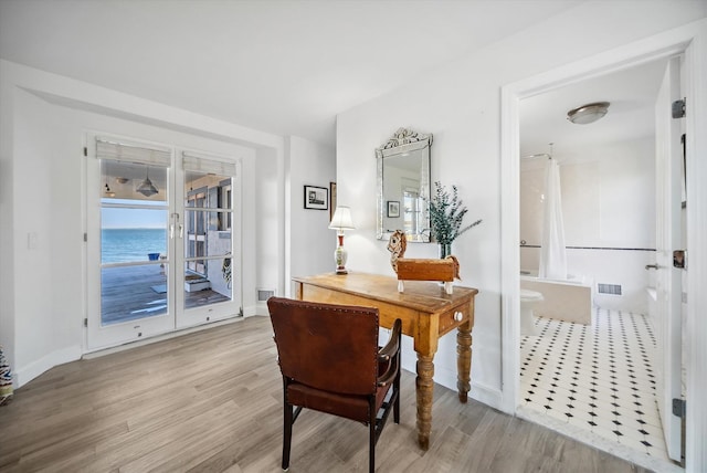 dining room with a water view and light wood-type flooring