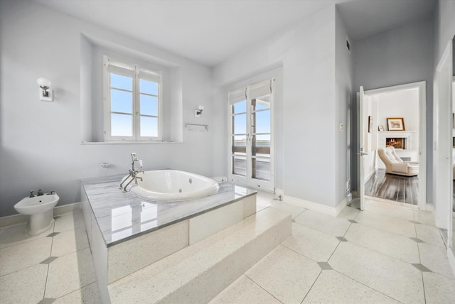 bathroom featuring a bidet and a relaxing tiled tub