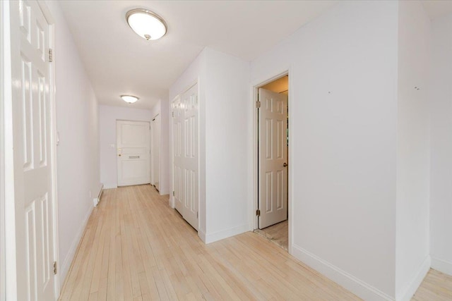 hallway with light hardwood / wood-style floors