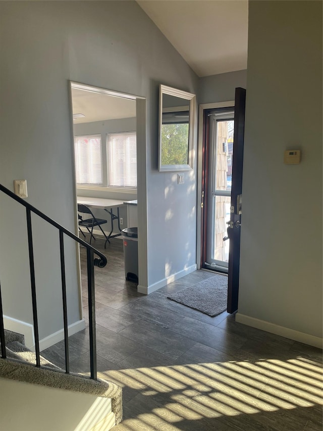 foyer with dark hardwood / wood-style floors and vaulted ceiling