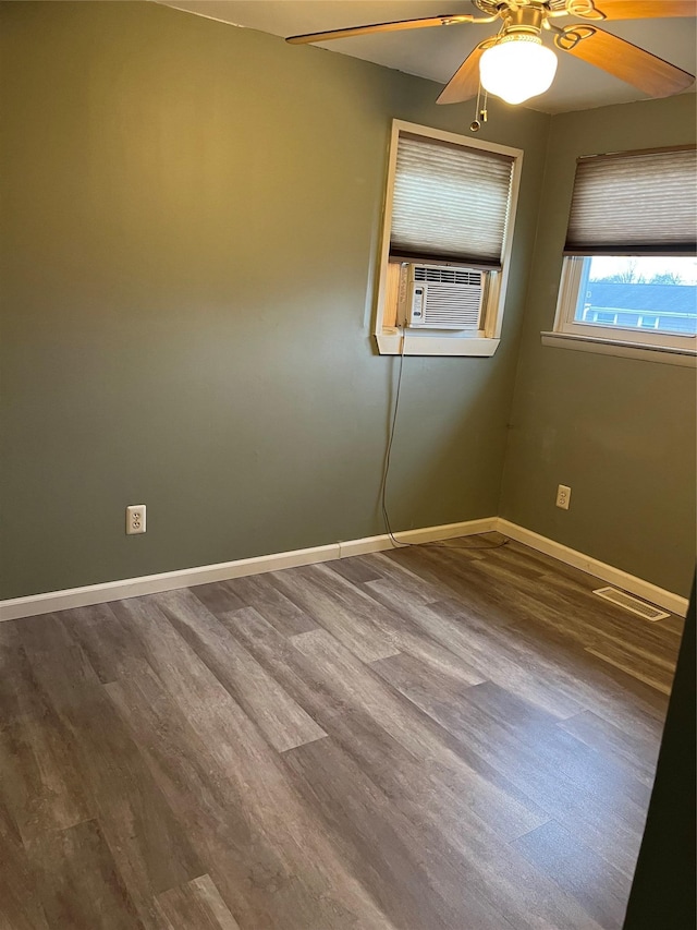 empty room with hardwood / wood-style floors, ceiling fan, and cooling unit