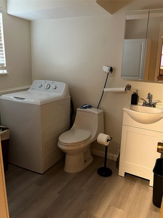 bathroom with wood-type flooring, toilet, washer / dryer, and vanity