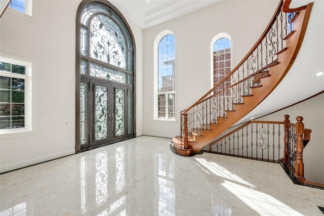 foyer featuring crown molding and a towering ceiling