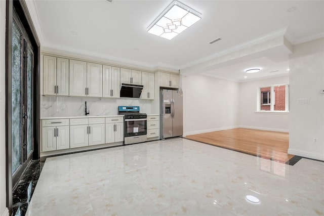 kitchen with stainless steel appliances, crown molding, and cream cabinets