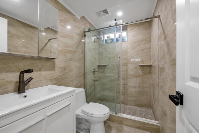 bathroom featuring tile walls, vanity, a shower with shower door, and toilet