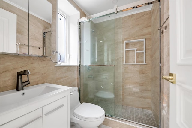 bathroom with vanity, toilet, an enclosed shower, and tile walls