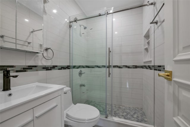 bathroom featuring vanity, tile walls, toilet, and walk in shower