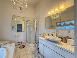 bathroom featuring an inviting chandelier, vanity, an enclosed shower, and tile patterned flooring