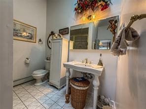 bathroom with tile patterned flooring, a baseboard radiator, and toilet