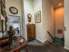 hallway featuring dark colored carpet