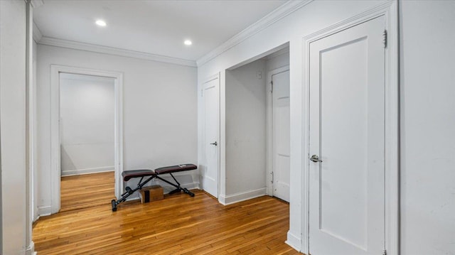 corridor featuring crown molding and light hardwood / wood-style floors