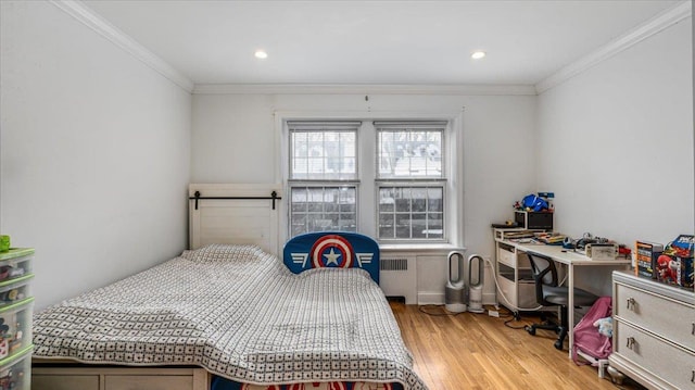 bedroom featuring hardwood / wood-style flooring, ornamental molding, and radiator