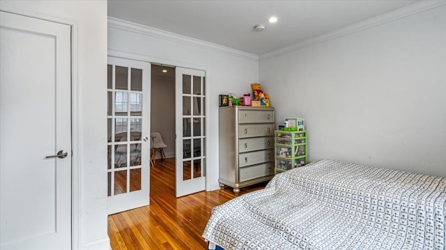 bedroom featuring french doors, wood-type flooring, and crown molding