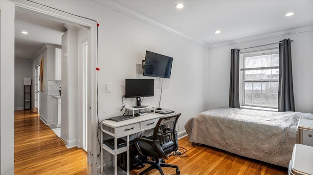 bedroom featuring decorative columns, ornamental molding, and light hardwood / wood-style floors