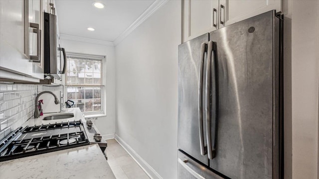 kitchen with stainless steel refrigerator, white cabinetry, backsplash, ornamental molding, and light stone countertops