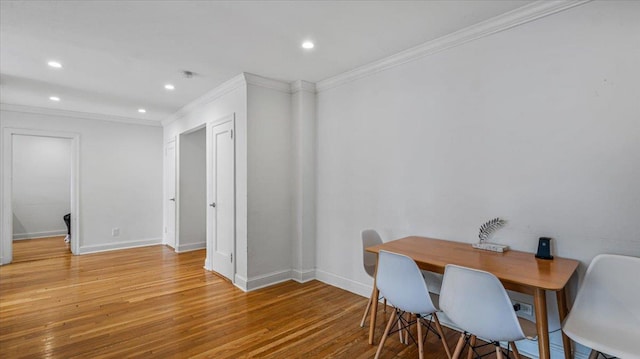 dining space with ornamental molding and hardwood / wood-style floors