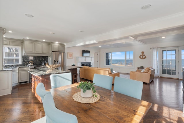 dining space with coffered ceiling, sink, crown molding, dark hardwood / wood-style floors, and beam ceiling