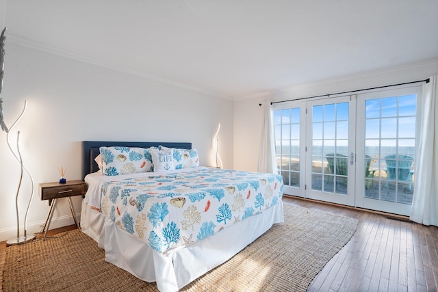 bedroom with wood-type flooring, ornamental molding, and access to outside