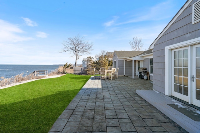 view of patio with a water view, a grill, and french doors