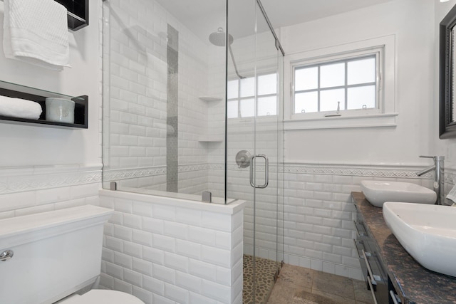 bathroom featuring walk in shower, tile patterned floors, toilet, tile walls, and vanity