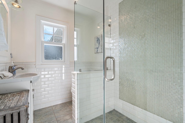 bathroom featuring tile patterned floors, a shower with door, tile walls, and vanity