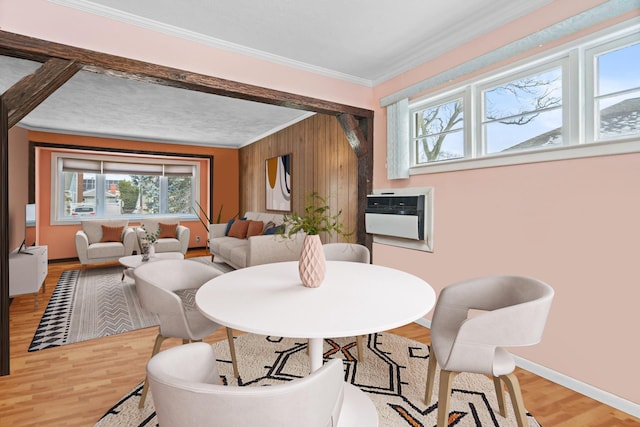 dining area featuring hardwood / wood-style flooring, ornamental molding, a wall unit AC, and wood walls