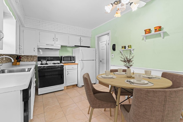 kitchen with sink, white cabinetry, gas range oven, light tile patterned flooring, and white fridge