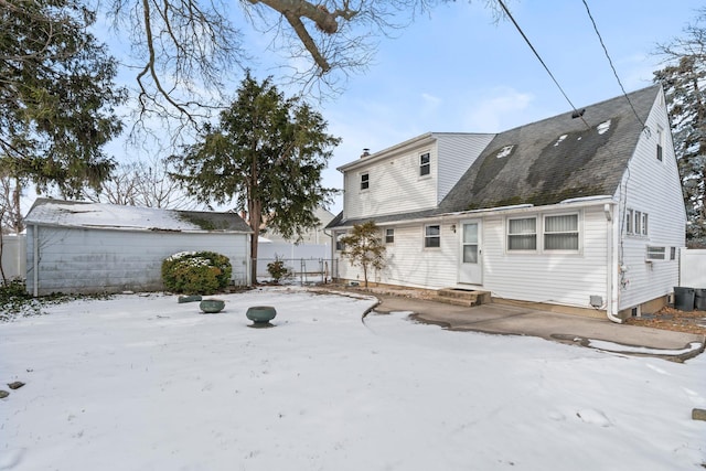 snow covered back of property featuring a wall mounted AC