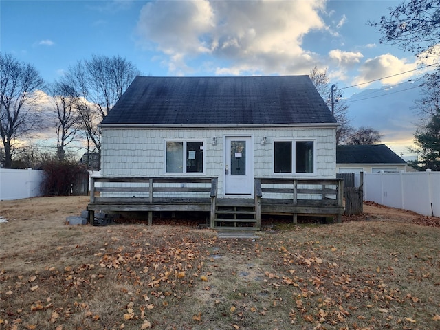 back house at dusk with a deck