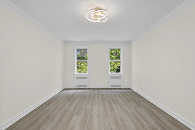 spare room featuring radiator, ornamental molding, and light hardwood / wood-style floors