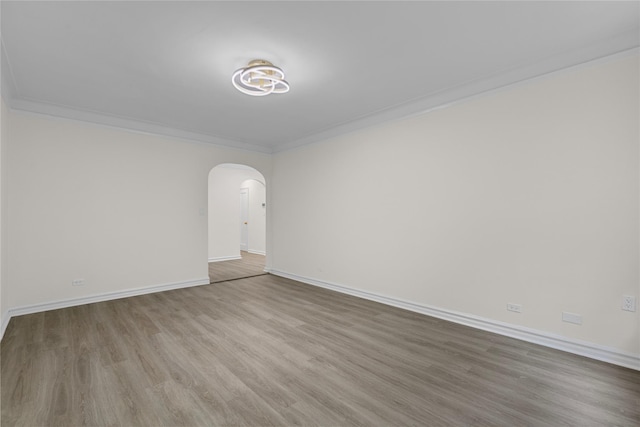 empty room with hardwood / wood-style flooring and ornamental molding