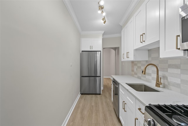 kitchen with appliances with stainless steel finishes, white cabinetry, sink, ornamental molding, and light stone countertops