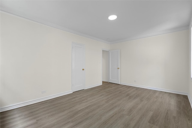 empty room featuring hardwood / wood-style floors and ornamental molding