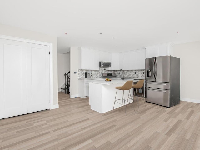65 W 2nd St Unit 7, Mount Vernon, NY 10550 - kitchen with backsplash, stainless steel appliances, baseboards, and light wood-style floors