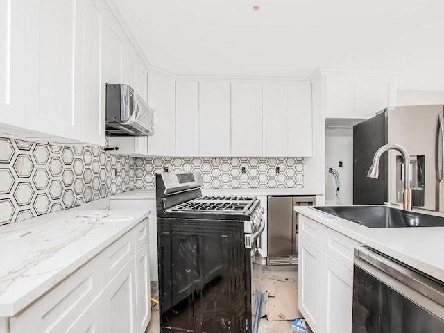65 W 2nd St Unit 7, Mount Vernon, NY 10550 - kitchen featuring white cabinets, stainless steel appliances, a sink, and tasteful backsplash