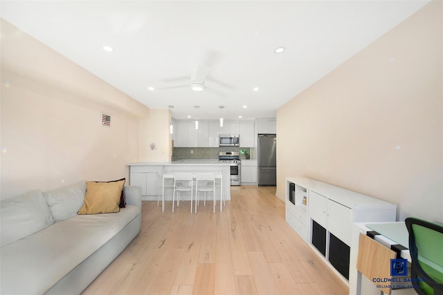 living room with ceiling fan and light wood-type flooring