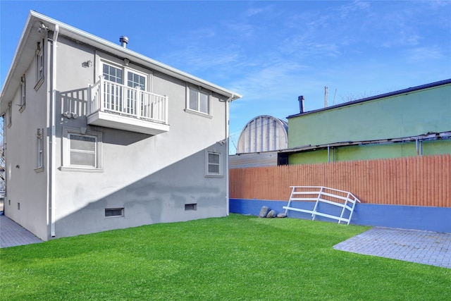 back of house with a patio, a balcony, and a yard