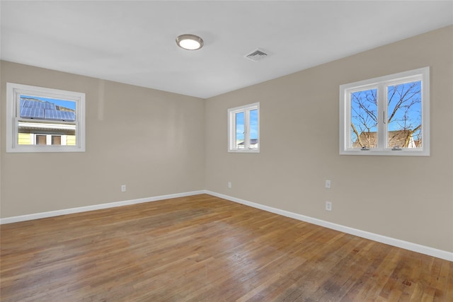 spare room featuring light hardwood / wood-style flooring and a healthy amount of sunlight