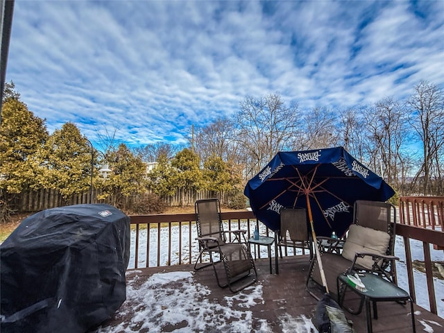 snow covered deck with a grill