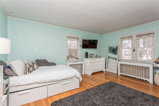 bedroom featuring hardwood / wood-style floors and radiator heating unit