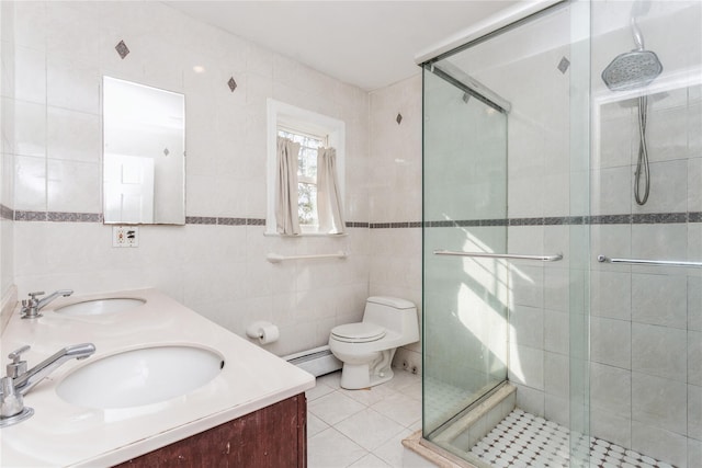 bathroom with tile walls, vanity, a shower with shower door, and baseboard heating