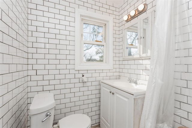 bathroom with vanity, toilet, curtained shower, and tile walls